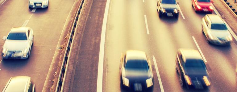 Automobili indistinte che percorrono la strada.